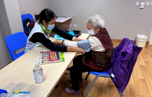 CDME volunteer checks the blood pressure of the elders to evaluate their health.